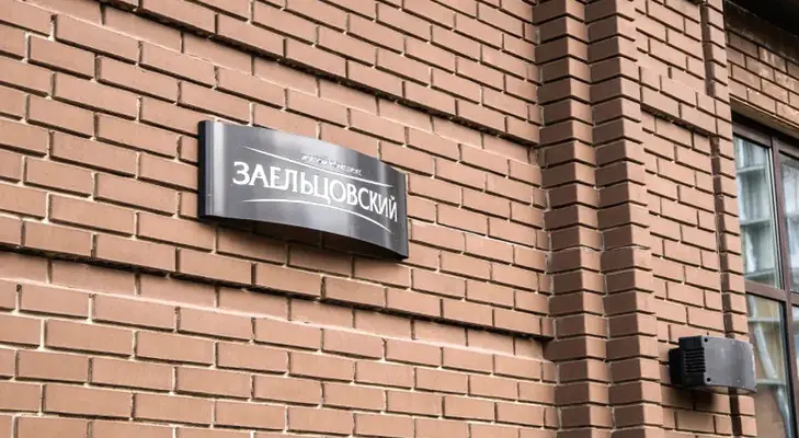 ЖК Заельцовский табличка с логотипом на фасаде дома